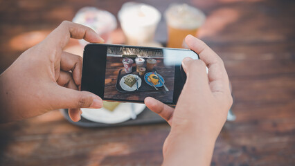 Woman Hands Taking Photographs Foods on Her Mobile Phone, Customer Woman Using Smartphone Take a Picture Food for Sharing Her Friends in Cafe and Restaurant Shop. Technology Digital Smart Phone