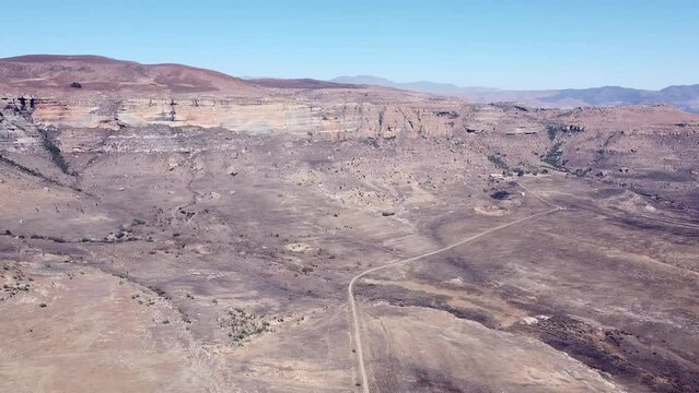 Aerial drone shot panning 360 degrees showcasing the remote dry vast scenic landscape and spectacular limestone mountain cliffs of the Drakensberg, KwaZulu Natal, South Africa    