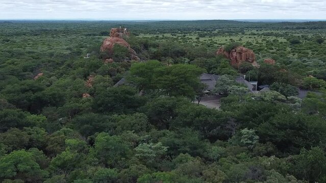 Aerial drone shot approaching a remote bush camp resort situated in the vast lush green African savanna, South Africa