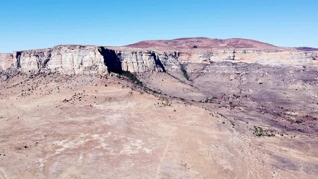Aerial drone shot ascending up revealing the beautiful sandstone mountains of the Drakensberg on a beautiful sunny day, KwaZulu Natal, South Africa