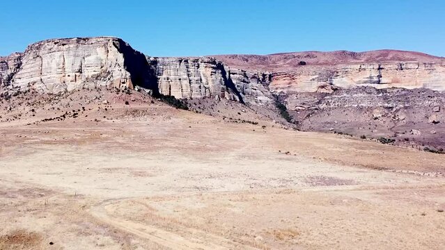 Aerial drone shot rising up exposing the beautiful sandstone cliffs and mountains of the Drakensberg, the area filled with amazing scenery and picturesque landscapes, KwaZulu Natal. South Africa 