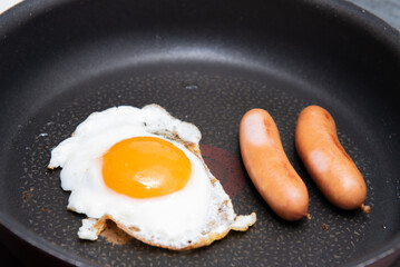 朝食に目玉焼きとウインナーを焼く