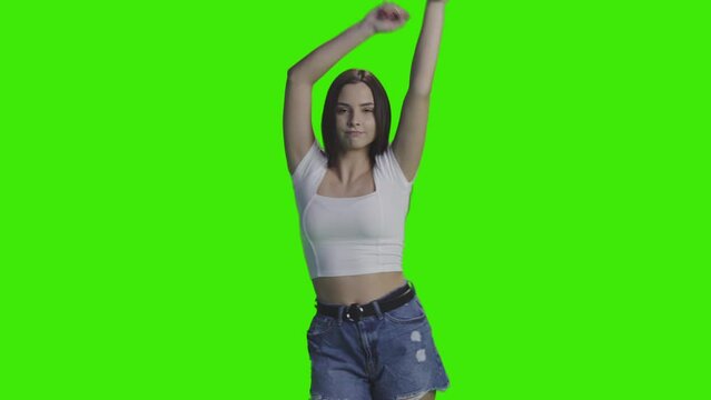 The beautiful girl is dacing around the concert, shaking her hand on greenscreen