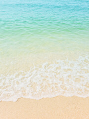 Views of beautiful white sand beaches and turquoise waters. Summer vacation beach background. Waves of the sea on a vertical sandy beach.