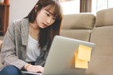 Young adult asian student woman learning at home indoor on day.
