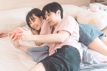 Obraz na płótnie Canvas Happy young adult asian lover couple living together in bedroom at home.