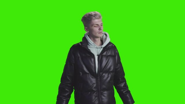A cheering boy wearing black jacket dancing and shaking his body on greenscreen
