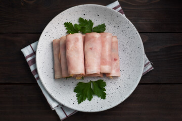 Ham and cheese rolls on a plate. Delicious appetizer meat carbonate and cream cheese.