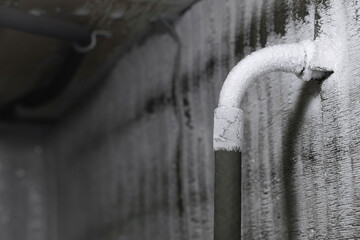 Frozen plumbing with a thick layer of white frost in the chilly cold winter. The frozen water pipe...