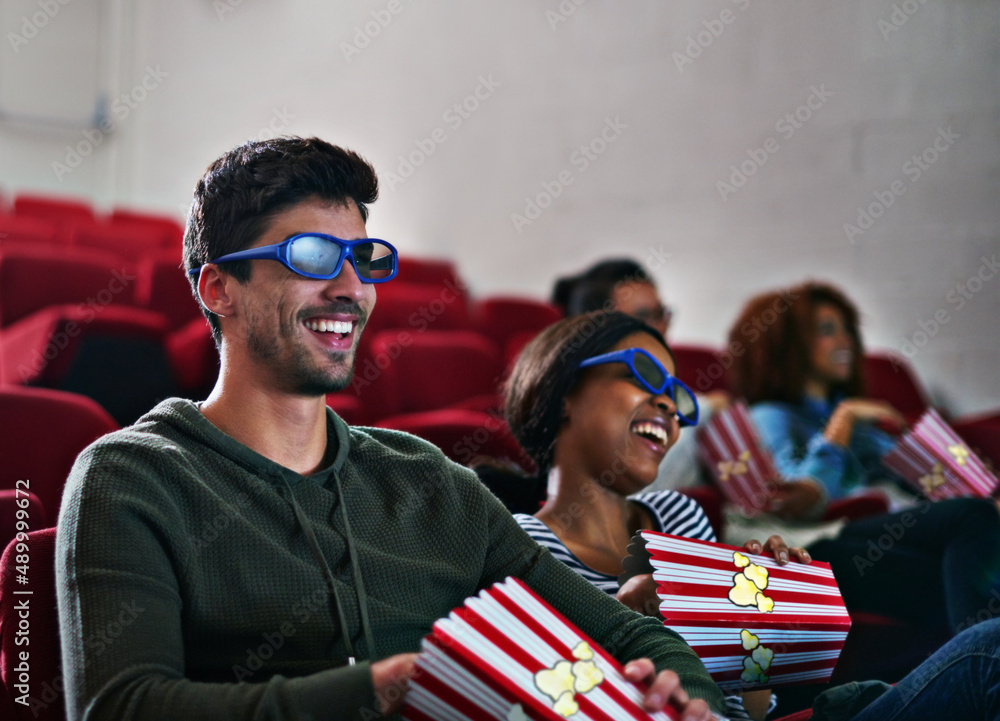 Sticker Thrills and spills never looked this good. Shot of a man and woman laughing while watching a 3D movie at the cinema.