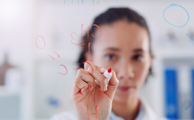 Studying new scientific matter. Shot young scientist drawing molecular structures on a glass wall...