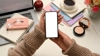 Fototapeta na wymiar A millennial girl holding modern smartphone white screen mockup