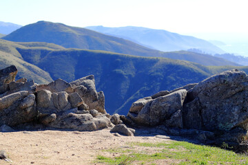 A point of view from the top of the cliff. View of the mountain range through the stones