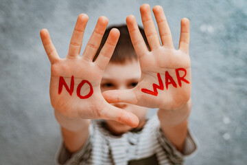 slogan of peace without war is written on the child's hand in red no war.