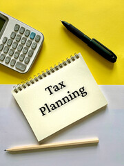 Tax planning text on notepad with calculator and pen background. Business concept.