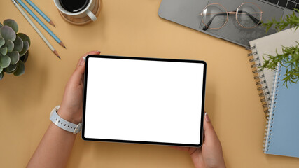 Obraz premium Comfortable workspace with office accessories and female holding tablet