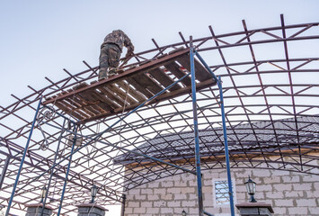 Workers are installing a metal canopy.