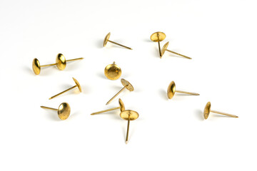 Golden pushpins on a white background, close view, close-up. Stationery. Equipment for working with documents.