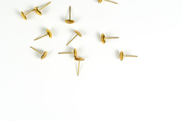 Golden pushpins on a white background, close view, close-up. Stationery. Equipment for working with documents.