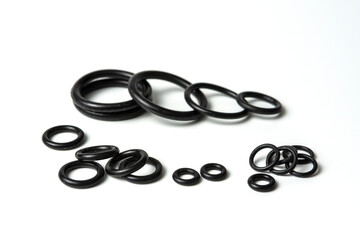 Naklejka premium Hydraulic and pneumatic o-rings in black in different sizes on a white background. Various seals for plumbing. Sealing rings for hydraulic connections.