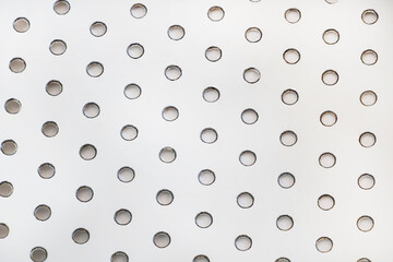 Close up shot of some holes in a metal plate textured