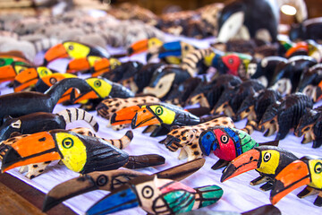 Fototapeta premium Argentina, Iguazu, June 07, 2019: Sale of souvenirs at the waterfalls. Toucans, animals, coatis planed from wood figures. Selective focus