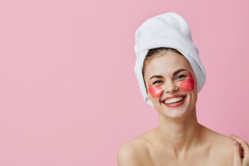 young woman pink patches on the face with a towel on the head close-up Lifestyle