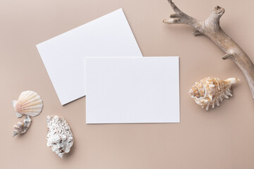 Minimal paper card mockup on beige background with dry branches and seashell