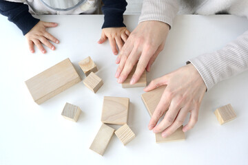 Fototapeta na wymiar 積み木遊びをする親子の手