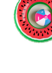 Top view closeup studio shot of colorful red and green watermelon with black seeds round shape swimming pool lifesaver kid rubber ring using on sea beach vacation placed on white background.