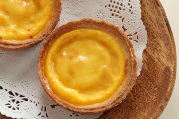 Asian sweet dessert, egg tart on wooden plate with copy space