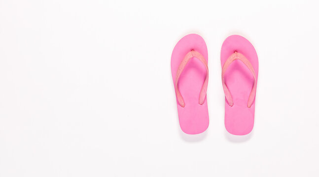 Closeup top view studio isolated shot pair of fashionable beautiful bright pink casual comfortable unisex rubber material slipper, flip flop, sandal, footwear on white background with copy space.