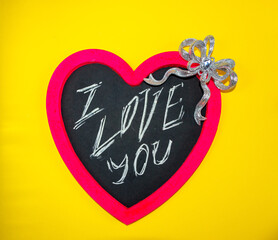 Wooden board for inscriptions chalk in shape of pink heart with various festive accessories and...
