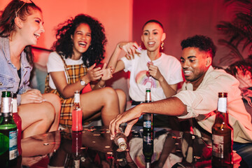 Friends playing spin the bottle at a house party