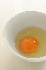 raw egg in white bowl with copy space