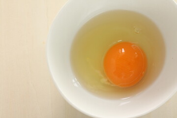 raw egg in white bowl with copy space