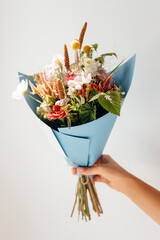 photo of a bouquet created from wild fresh spring flowers photographed on a white background in...