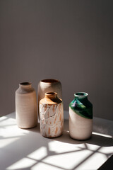 minimalist handmade clay vases on a white background with daylight