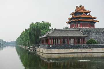 Fototapeta premium Beijing / China - 08.06.2012 : Gazebo in the old traditional style in the forbidden city. View from the river with reflection.