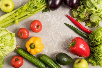 a frame of fresh vegetables on a gray concrete background with space for text. organic, natural, healthy food. flat layout.