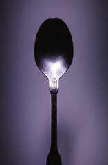 One Metal Spoon on Purple Background