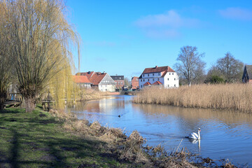 Mill pond of the small town Rehna with park and old town houses against the blue sky in Mecklenburg-Western Pomerania, Germany, copy space