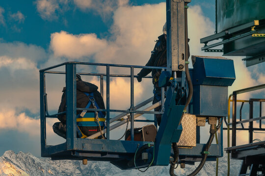 Assemblers repairing a harbor crane on a high lift