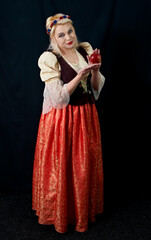 Naklejka premium Ukrainian pretty woman holding apple on black background