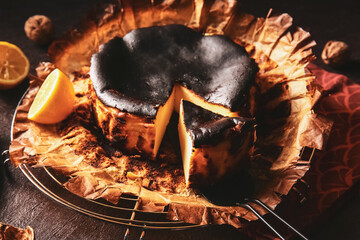 Tasty Basque burnt cheesecake on dark background
