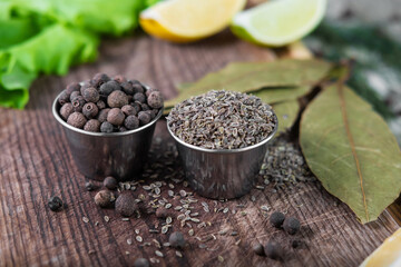 Pile of black pepper and caraway grain in vintage wooden background. Seasonings for cooking various dishes.
