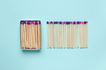 Box with different new matchsticks on blue background