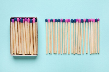 Box with different new matchsticks on blue background