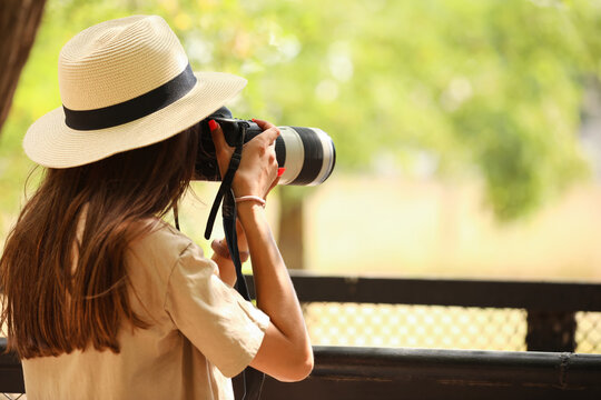 Young female photographer in zoological garden