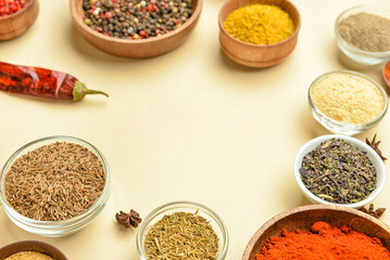 Bowls with aromatic spices on yellow background